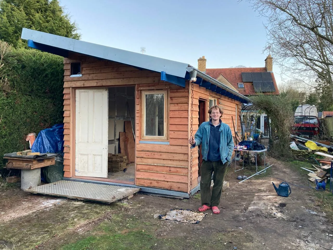 Kai standing in front of his nearly completed studio project